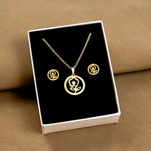 Detailed view of a gold rose jewelry set in a luxury white gift box with black padding