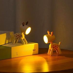 Due graziose luci notturne a LED a forma di cervo che brillano di luce calda sui libri