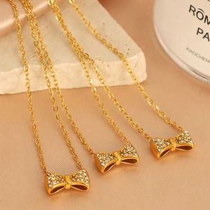 Collier élégant en acier titane doré avec pendentif nœud serti de cristaux blancs
