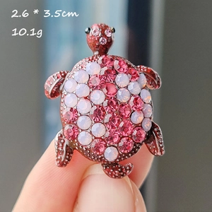 Macro view of crystal turtle brooch with pink and white rhinestones and size details