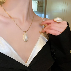 Vue détaillée du collier et de la bague plaqués or avec de grandes perles blanches