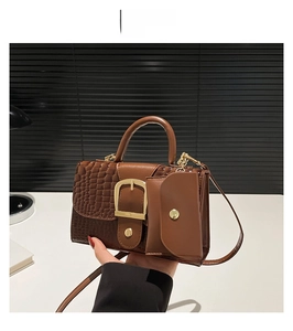 Détail du sac à main marron café à motif crocodile avec boucle dorée et mini pochette