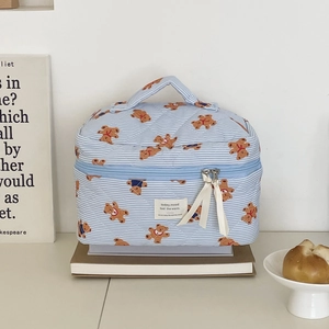 Quilted blue striped cosmetic bag with bear pattern and ribbon detail on books