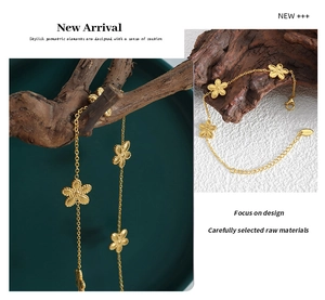 Detailed view of a gold daisy charm bracelet with intricate chain links and hallmark tag
