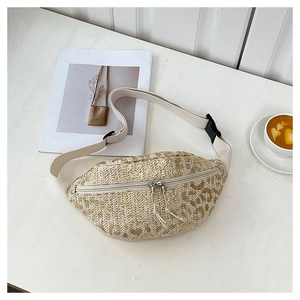 Flat lay of a woven straw waist bag with leopard pattern next to a coffee cup
