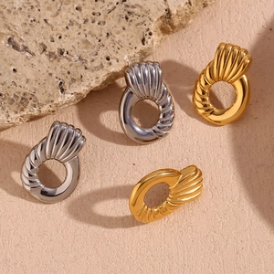 Detailed view of gold and silver plated geometric hoop earrings with textured finish
