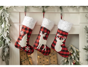 Detailed view of plaid Christmas stockings with reindeer appliques hanging on a festive mantel