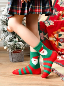 Detailed view of child wearing festive cotton socks with Santa Claus pattern and stripes