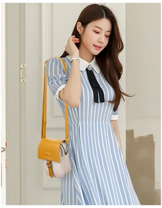 Detailed shot of yellow and beige contrast mini crossbody bag worn on shoulder by a model