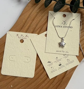 Star pendant necklace with polished silver chain on a custom jewelry display card