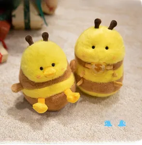 Detail showing two plush bee duck dolls with fluffy fur texture and yellow color theme