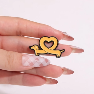 Broche minimaliste en émail teckel avec cœur de chien créatif portée sur les doigts