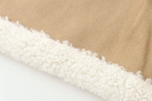Macro shot of camel suede fabric and white faux shearling texture on a jacket sleeve