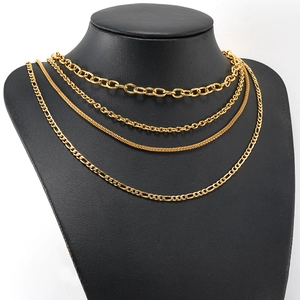 Golden multi-layer stainless steel necklace with cuban and link chains on black mannequin