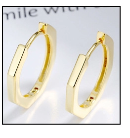 Macro shot of gold geometric earrings showing the S925 hallmark for premium quality