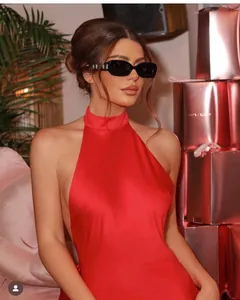 Detail of red backless halter dress paired with black square vintage sunglasses
