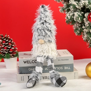Detailed plush Christmas gnome with long checkered legs sitting on books by a tree