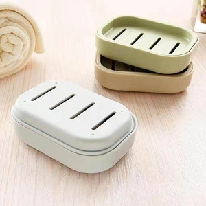 Detail of multi-color double-layer soap dishes with drainage holes on a wooden surface