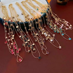 Collier multicouche doré avec zircons colorés présenté sur une boîte à bijoux
