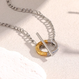 Détail du fermoir à bascule OT bicolore argent et or 18 carats sur un collier élégant