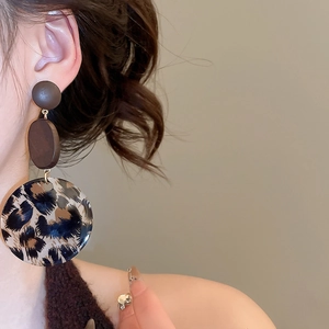 Detailansicht der Retro-Ohrhänger mit Leopardenmuster am Model für einen eleganten Look
