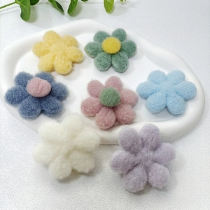 Handmade colorful wool felt flower accessories on a white ceramic tray, group display