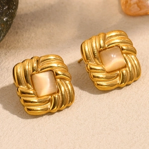 Macro detail of 18K gold square cat eye earrings with vintage braided metal texture