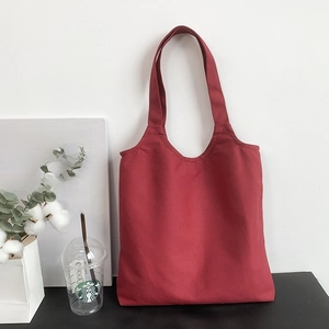 Detailed texture of thick dark red cotton canvas on a large minimalist tote bag