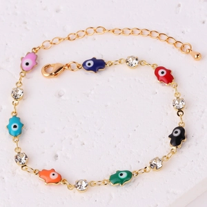 Dettaglio di bracciale a catena dorata con ciondoli Hamsa in smalto colorato e cristalli