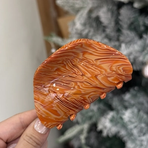 Orange marble textured acetate hair claw clip with elegant semi-circle design