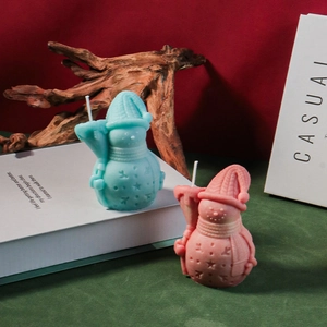Close-up of snowman scented candles in blue and pink with intricate star patterns