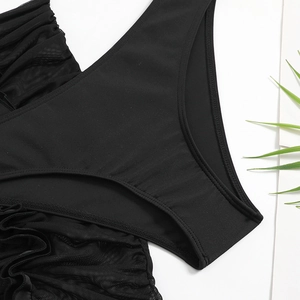 Dettaglio dello slip bikini nero con inserti in mesh e bordi arricciati elastici