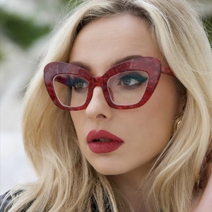 Close-up of stylish red cat-eye oversized glasses frames on a female model face