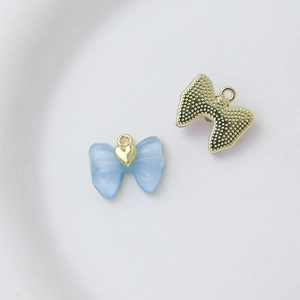 Detailed front and back views of a light blue bow charm with a golden heart for DIY jewelry