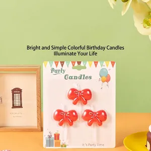Set of 3 red bowknot birthday candles with white holders on colorful party backing card