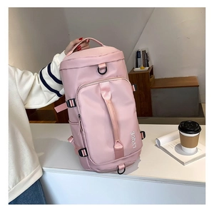 Detail of pink cylindrical travel bag with reinforced D-rings and top handles