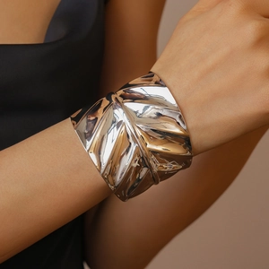 Detailed view of silver metallic leaf cuff bracelet with textured veins on female wrist