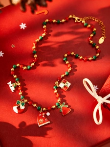 Détail du collier de perles de Noël avec cloches colorées et pendentifs cadeaux