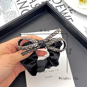 Elegant black satin hair scrunchie featuring a large silver rhinestone bow ornament