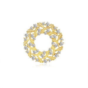 Detailed view of a golden wreath brooch featuring intricate leaf textures and sparkling crystals