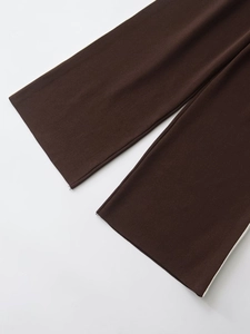 Detail of dark brown knit sleeves with white side stripes showing fabric texture