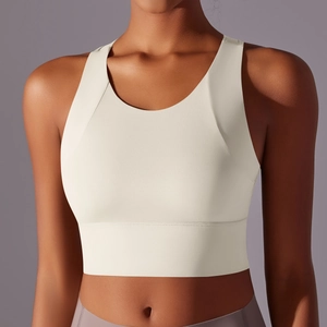 Close-up of cream yoga sports bra featuring a round neck and wide elastic hem