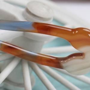 Detailed close-up of U-shaped acetate hair pin showing amber and blue gradient texture