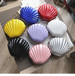 Macro detail of eight colorful shell-shaped hard shell bags with gold chain straps