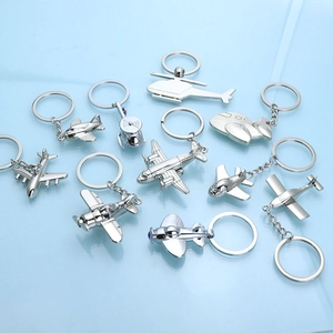 Polished silver zinc alloy airplane keychains in various aircraft models on blue background
