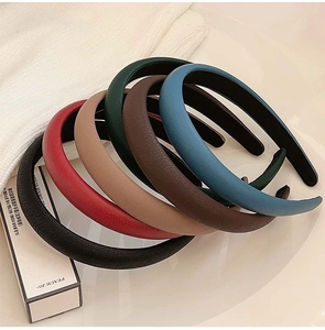 Detailed close-up of six padded faux leather headbands in assorted classic colors