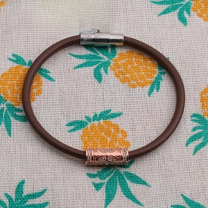Close-up of brown leather cord bracelet with rose gold zircon beads and magnetic clasp