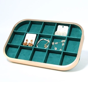 Detailed view of dark green velvet jewelry tray with multiple storage compartments