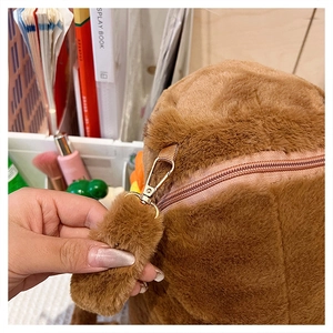 Close-up of the metal lobster clasp and zipper on a brown plush Capybara backpack
