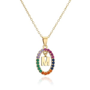 Detail view of gold letter M pendant necklace with colorful rainbow zircon stones